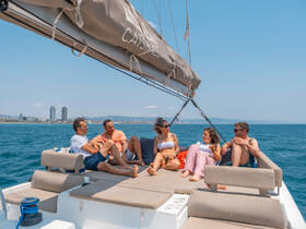 A group of friends enjoys a relaxing day on a catamaran, soaking up the sun and ocean views — perfect for a memorable outing on the water.