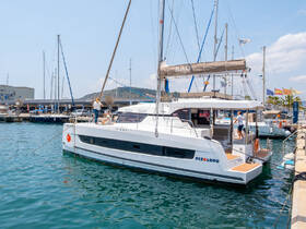 A sleek catamaran named 'Pez Lobo' docked at a marina, showcasing its modern design and inviting atmosphere for sailing adventures.