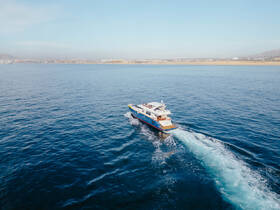 A stunning aerial view of a yacht cruising through calm waters, showcasing its elegant design and vibrant colors — perfect for luxury charters and scenic adventures.