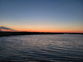 A serene sunset over calm waters, showcasing the beauty of nature — perfect for peaceful evening boat rides.