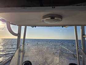A view from the helm of a boat, showcasing the console and the expansive ocean ahead, perfect for navigation enthusiasts.