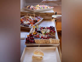 A beautifully arranged charcuterie platter featuring a variety of fruits, cheeses, and snacks, perfect for onboard catering during a luxurious boat trip.