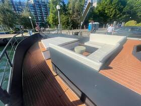 A stylish lounge area on a boat featuring comfortable seating, perfect for relaxing while enjoying the waterfront views.