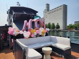 A beautifully decorated seating area on a boat, featuring colorful balloons and a festive atmosphere, perfect for celebrations or gatherings on the water.