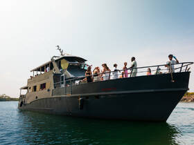 A lively group enjoys a celebration aboard a spacious boat, showcasing the perfect atmosphere for parties and gatherings on the water.
