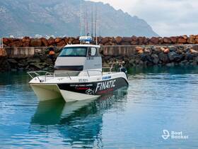 A sleek fishing charter boat, the Finatic, is docked in calm waters, showcasing its design and readiness for deep sea adventures.
