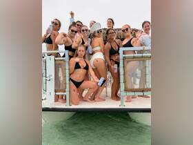 A lively group of women celebrates on a boat, showcasing their fun spirit with drinks and playful poses — perfect for bachelorette parties or summer gatherings on the water.