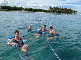 A group of friends enjoys a fun day swimming in clear waters, showcasing the perfect beach getaway experience.