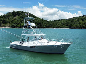 A sleek fishing boat navigates through clear turquoise waters, showcasing its impressive design and functionality, perfect for fishing adventures.