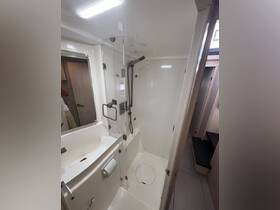 A modern boat bathroom featuring a spacious shower and sink area, designed for comfort and convenience while on the water.