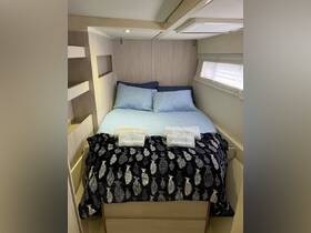 Cozy cabin interior featuring a comfortable bed with decorative pillows and towels, ideal for relaxing on a boat getaway.