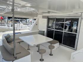 A spacious and modern interior of a boat featuring a comfortable dining area and seating, perfect for relaxing and enjoying meals while on the water.