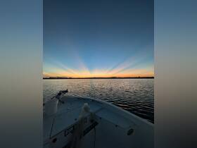 A serene sunset view from the bow of a boat, showcasing the tranquil waters and vibrant sky — perfect for peaceful evening cruises.
