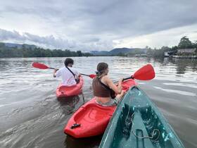 A couple enjoys kayaking on calm waters, surrounded by lush scenery — a perfect adventure for nature lovers.