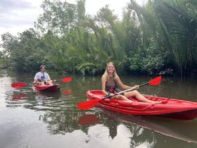 Two adventurers enjoy a serene kayaking experience through lush greenery, perfect for nature lovers and outdoor enthusiasts.