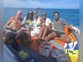 A lively group enjoys drinks and snacks on a boat, capturing the essence of a fun day on the water with friends.
