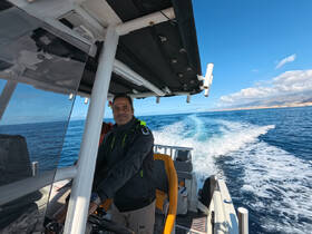A captain navigates a boat through the open ocean, showcasing the thrill of cruising on the water.