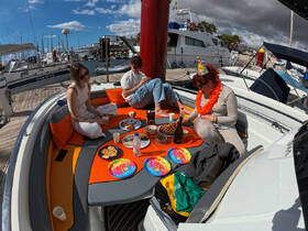 A lively group celebrates on a boat with food and drinks, perfect for festive gatherings and memorable moments on the water.