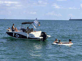A lively group enjoys a day on the water, with some relaxing on a float while others socialize on the boat — perfect for summer fun and memorable outings.