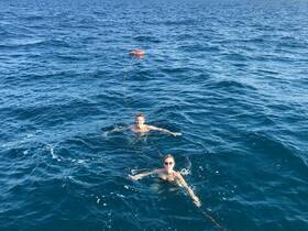 A couple enjoys a refreshing swim in the ocean, showcasing the fun and adventure of a day on the water.