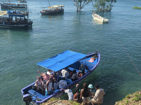 A lively group gathers on a colorful boat, enjoying a sunny day on the water — perfect for social outings and adventures.