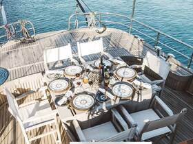 An elegantly set dining table on a yacht's deck, complete with fine dishes and drinks, perfect for a luxurious dining experience on the water.