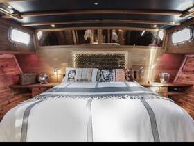 A cozy and stylish interior of a boat cabin featuring a comfortable bed and warm wooden accents, perfect for relaxing on the water.
