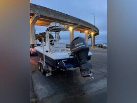 A sleek center console boat with a Yamaha outboard motor, parked under a bridge, showcasing its modern design and readiness for adventure.