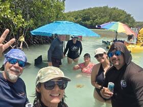 A lively group enjoys a fun day in the shallow waters of a mangrove, showcasing the perfect blend of relaxation and adventure.