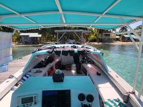An interior view of a boat's helm and seating area, showcasing a vibrant design and a glimpse of the surrounding tropical scenery.