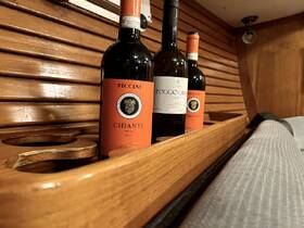 A selection of fine wines displayed in a cozy boat interior, perfect for enhancing any onboard dining experience.