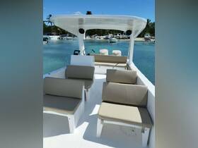 Interior view of a spacious boat cabin featuring comfortable seating and a helm, perfect for relaxing while enjoying a day on the water.