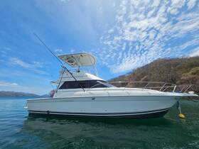 A sleek yacht is docked in calm waters, showcasing its elegant design against a backdrop of blue skies and distant hills — perfect for luxury boating experiences.