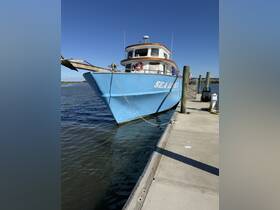 A vibrant blue boat named 'SEA LUV' docked at the pier, showcasing its charming exterior against a clear blue sky.
