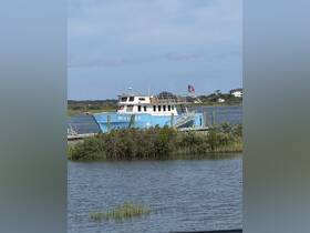 The 'SEA LIFE II' boat is docked in calm waters, surrounded by lush greenery, showcasing a serene boating environment.