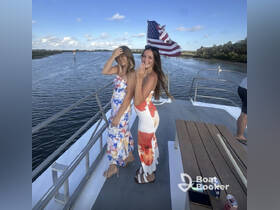 Two friends pose joyfully on the deck of a boat, enjoying a beautiful day on the water — perfect for memorable outings and celebrations.