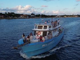 A lively group enjoys a cruise aboard the 'Sea Love II,' showcasing the perfect setting for celebrations and gatherings on the water.