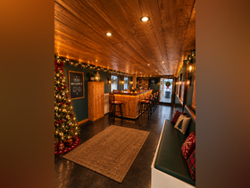 A beautifully decorated interior of a boat featuring a cozy bar area and festive holiday decor, perfect for gatherings and celebrations on the water.