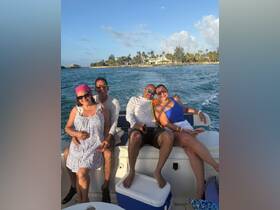 A cheerful group of friends enjoys a sunny day on the boat, capturing the essence of fun and relaxation on the water.