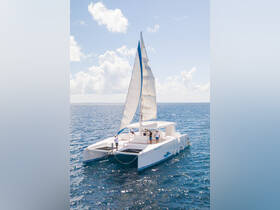 A stunning aerial view of a catamaran sailing on open waters, with guests enjoying the experience — perfect for adventure seekers and sailing enthusiasts.