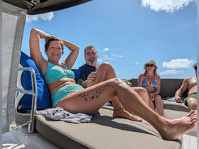 A joyful group enjoys a sunny day on the boat, relaxing and celebrating together — perfect for memorable outings with friends.