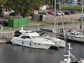 A beautiful yacht named 'Marel Lady' docked at a marina, surrounded by other vessels and a scenic view of the waterfront.