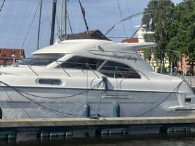 A sleek yacht named 'Memel Lady' docked at the marina, showcasing its elegant design and structure against a clear blue sky.