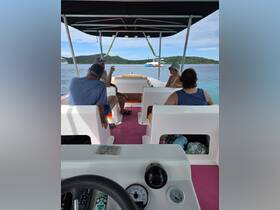 Inside view of a boat's cabin featuring guests seated and enjoying the ride, showcasing a comfortable and inviting atmosphere for a day on the water.