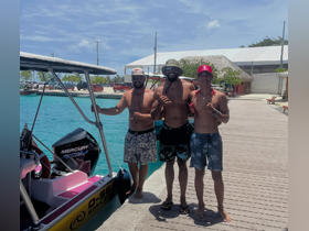 A group of friends poses by their boat, enjoying a sunny day by the water — perfect for adventure and fun on the waves.