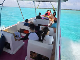 A lively group enjoys a boat ride through stunning turquoise waters, perfect for adventure and exploration.