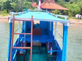 Interior view of a colorful boat featuring seating and a table, ideal for relaxing while enjoying the scenic waters.