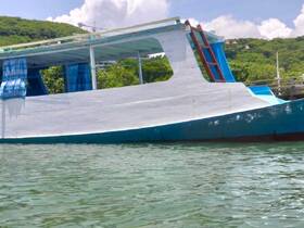 A close-up view of a colorful boat docked in calm waters, showcasing its unique hull design and vibrant colors, perfect for exploring coastal destinations.
