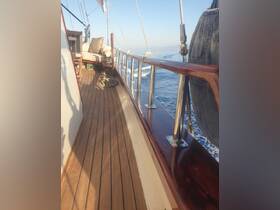 A cozy seating area on the deck of a sailboat, showcasing elegant wood finishes and a serene ocean backdrop — perfect for relaxation while cruising.