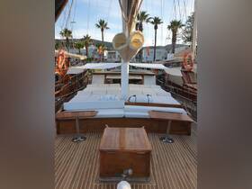 The interior of a spacious boat featuring comfortable seating and wooden accents, perfect for relaxing while enjoying the sea breeze.